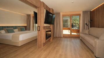 Una habitación de hotel moderna con cama, sofá, televisión y balcón con vistas.