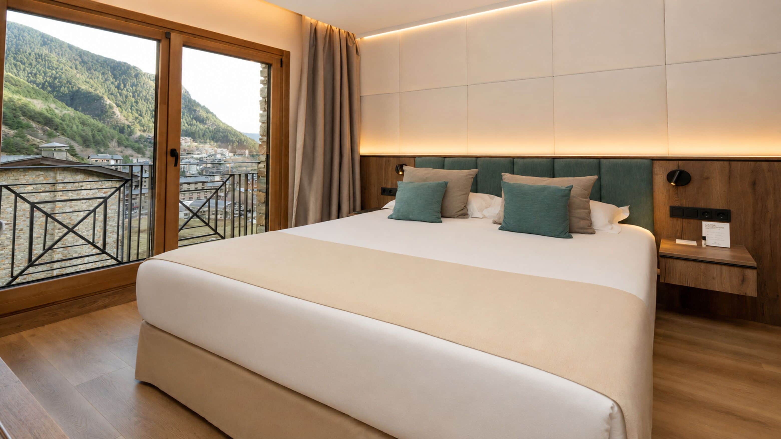 A large bed with a view of a balcony and mountains.