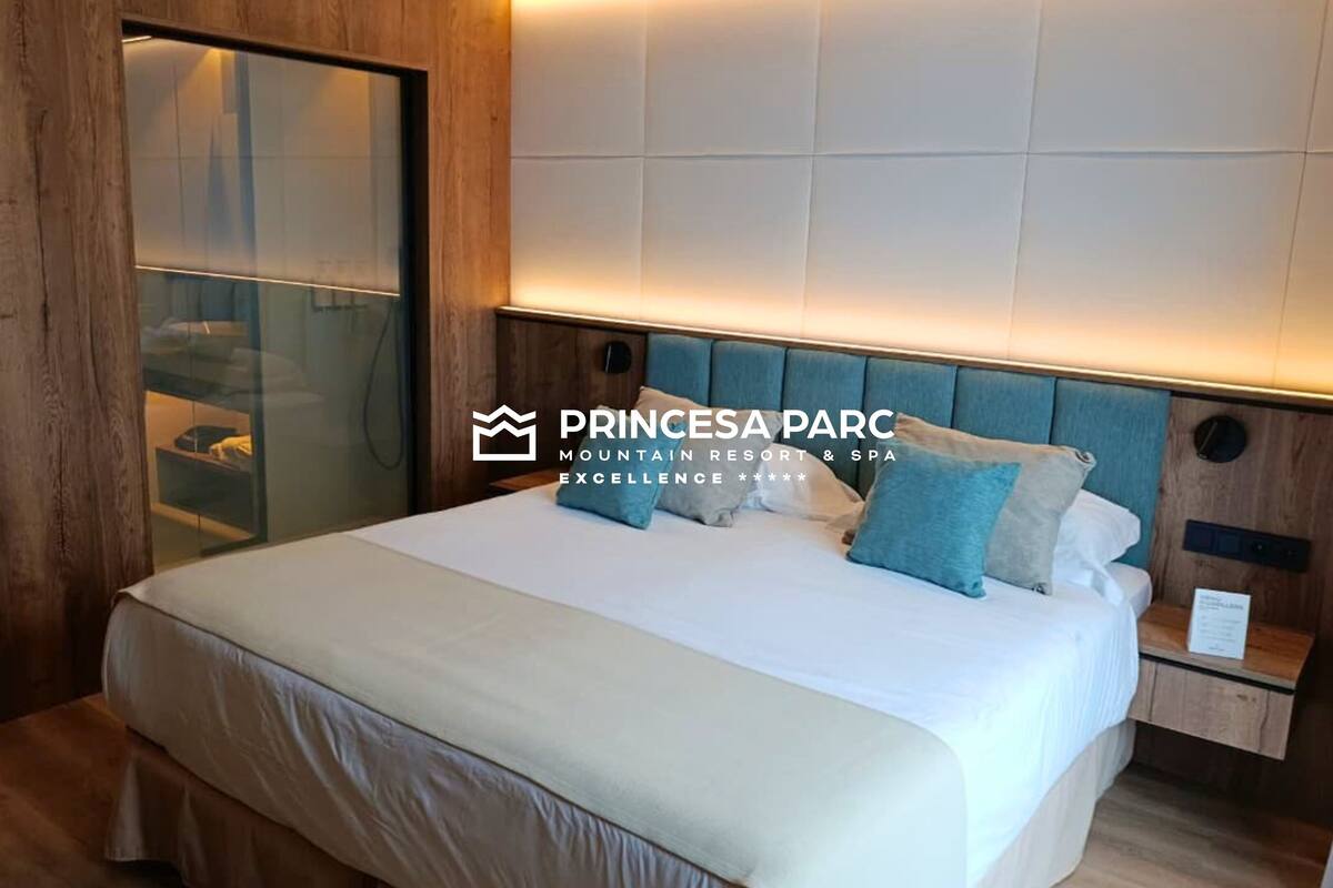 Un dormitorio con una cama grande, cabecero de madera y una mesita de noche con lámpara.