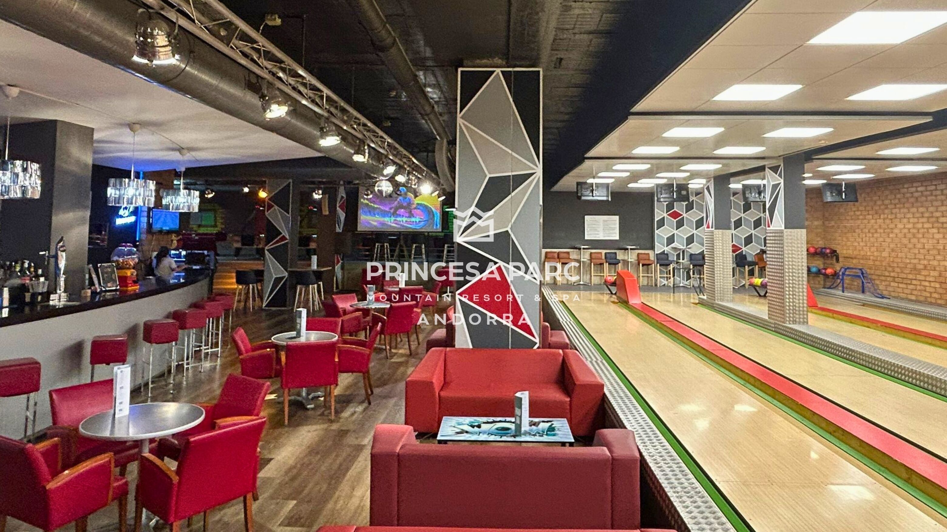 A bowling alley with red seating and a bar area.