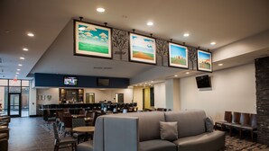 Un hall d’entrée avec un espace salon, un bar et un écran de télévision.