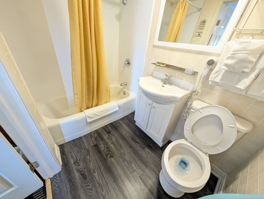 Ein Badezimmer mit Badewanne, Waschbecken, Toilette und Duschvorhang.