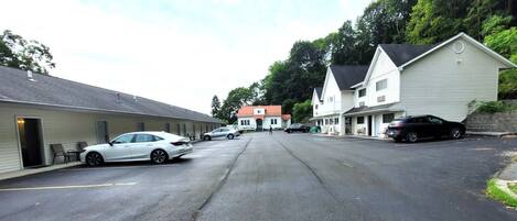 Une vue de rue avec une rangée de bâtiments, dont un motel devant lequel est garée une voiture.