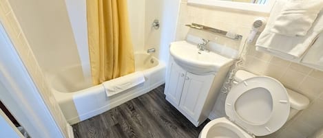 A bathroom with a bathtub, a sink, and a toilet.