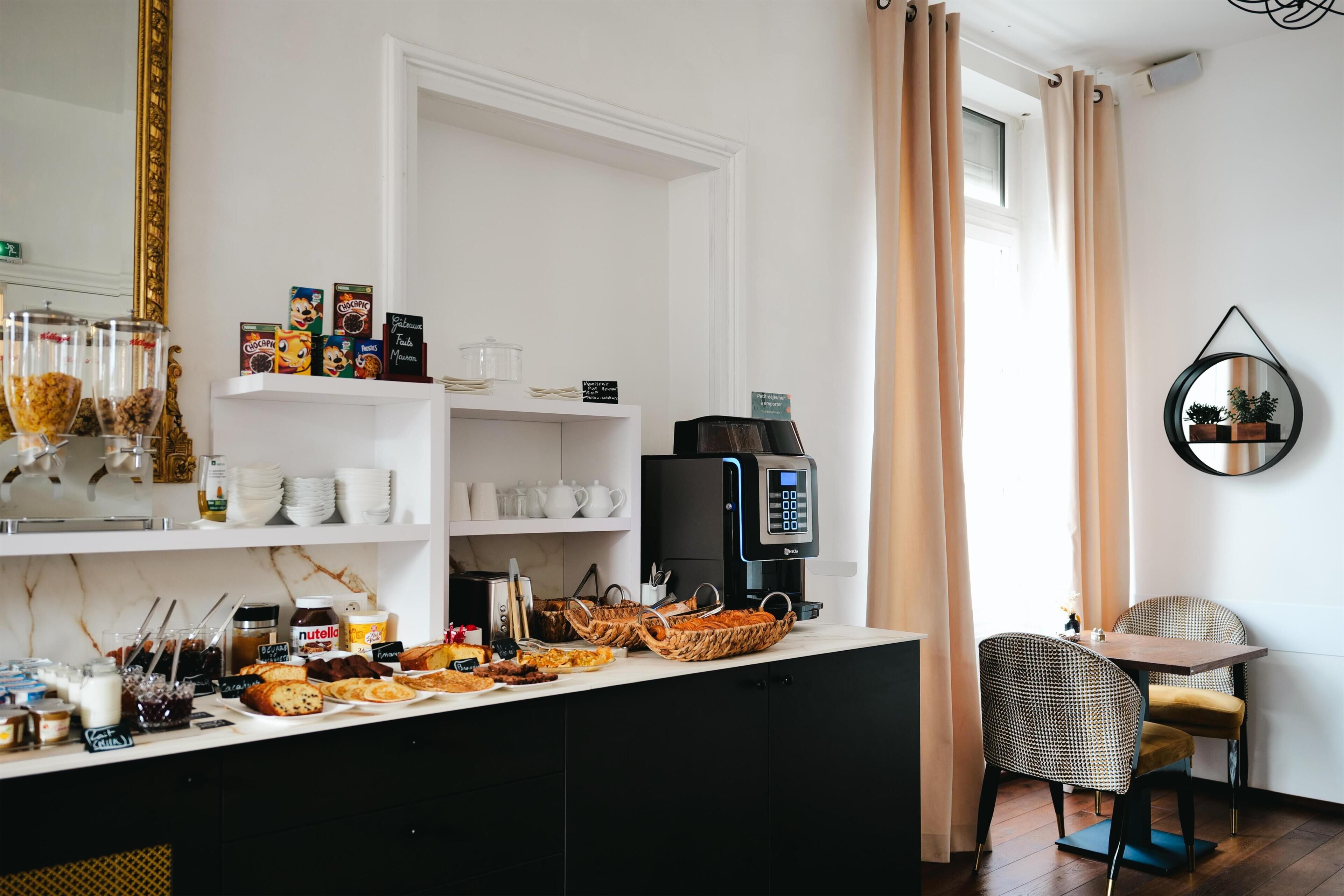 A kitchenette with a coffee machine, breakfast items, and a breakfast bar.
