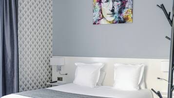 A modern bedroom with a bed, a wall-mounted artwork, and a textured wall panel.