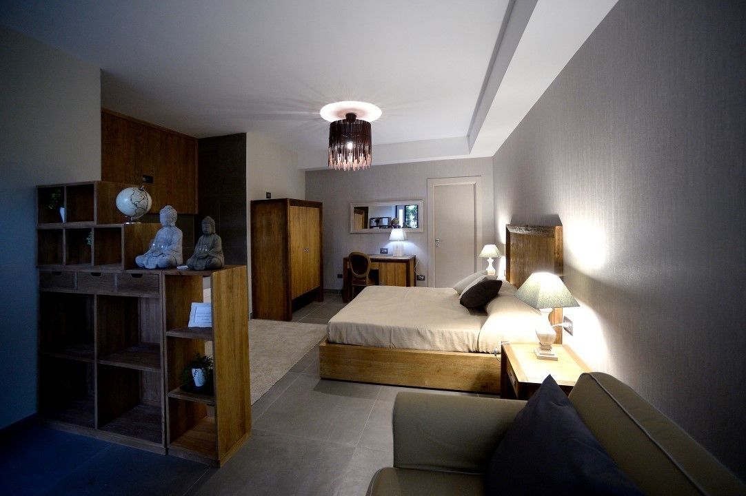Ein Schlafzimmer mit Bett, Nachttischen, einem Kleiderschrank, einem Schreibtisch und einem Spiegel.