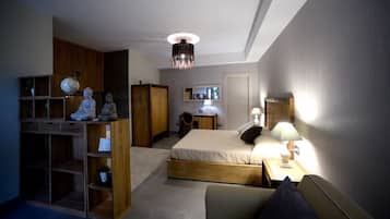 Ein Schlafzimmer mit Bett, Nachttischen, einem Kleiderschrank, einem Schreibtisch und einem Spiegel.
