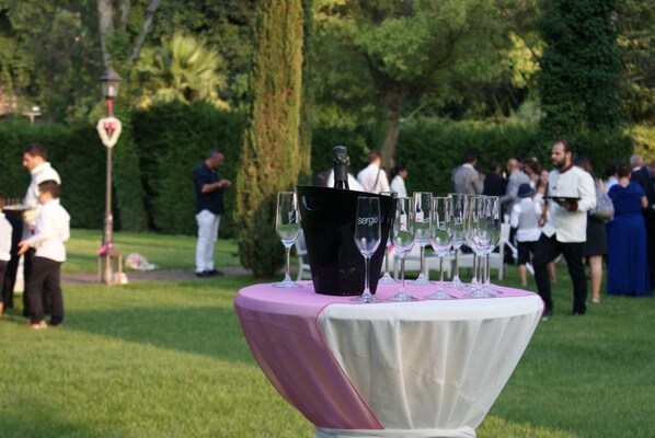 A table with a pink and white tablecloth, a bottle, and several wine glasses.