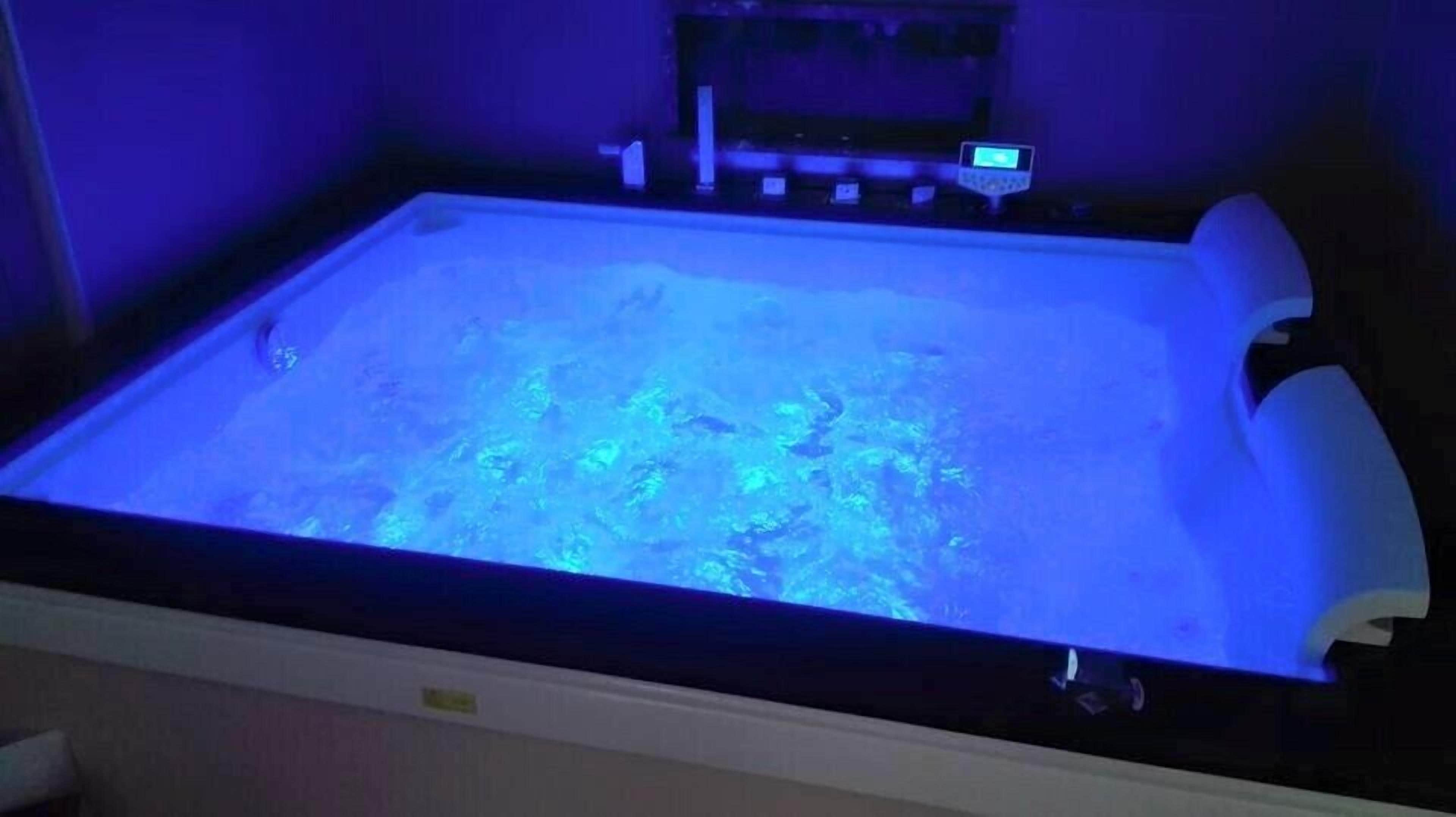 A bathtub with a digital control panel and a water jet system.