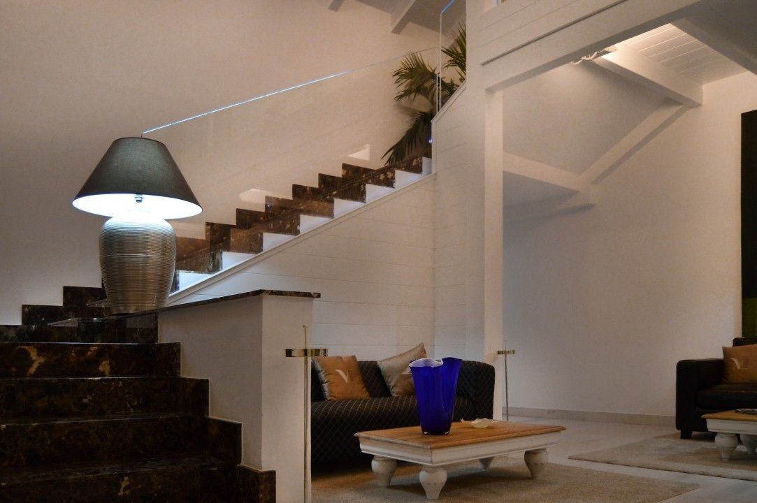 A modern interior with a staircase, a lamp, and a sofa.