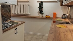 A modern kitchen with a wooden countertop, a sink, and a radiator.