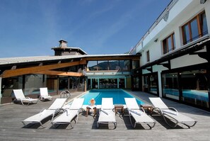 A poolside area with lounge chairs and a pool.