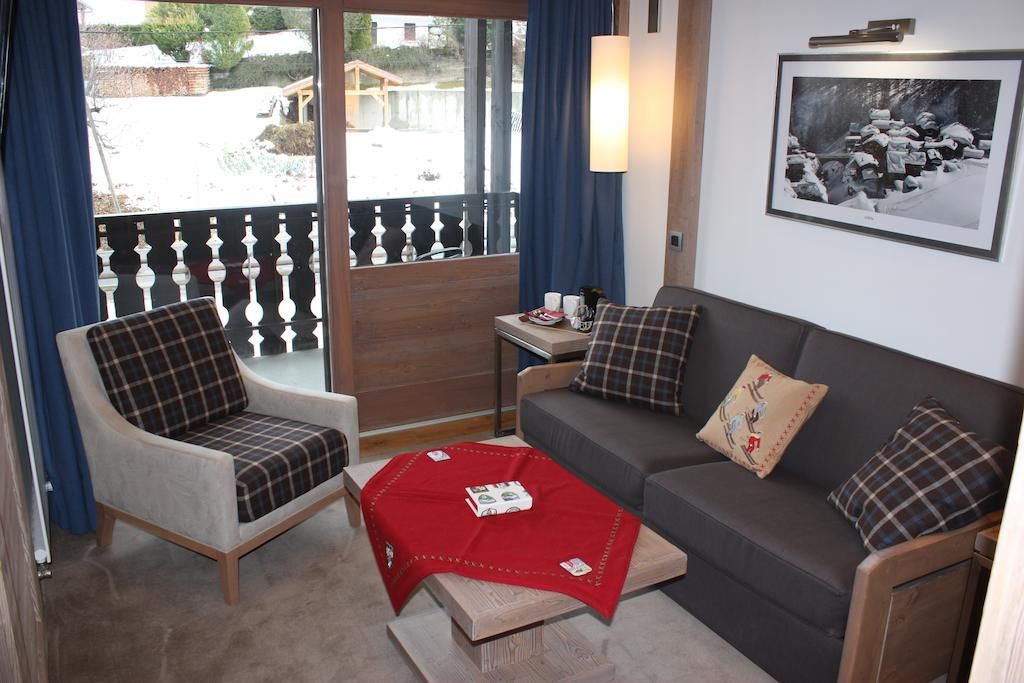 Et værelse med sofa, lænestol og et rødt bord med en bog.
