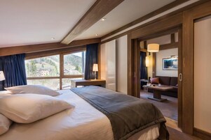 Habitación de hotel con una cama grande, un escritorio, un sofá y vistas al exterior.