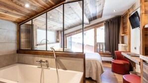 A modern bathroom with a large bathtub, wooden ceiling, and a large mirror.