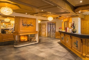 A wooden interior with a fireplace, a bar area, and a dining space.
