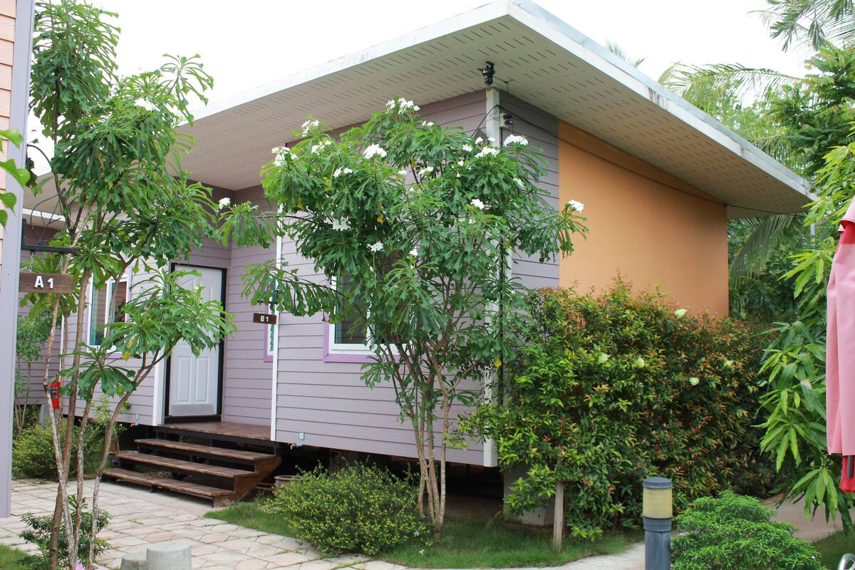 Ein eingeschossiges Haus mit Veranda, kleinem Garten und Briefkasten.