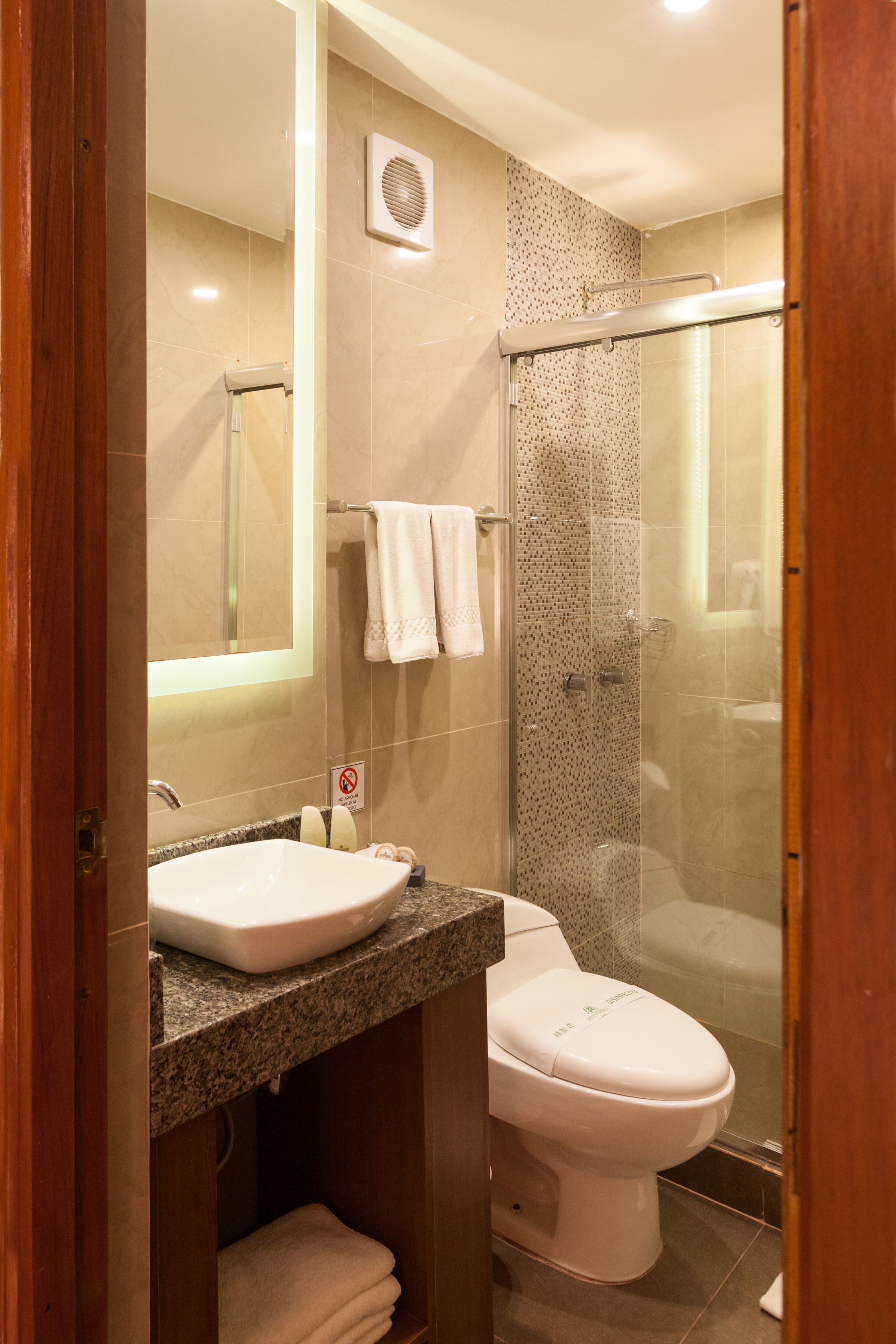 Un baño con lavamanos, inodoro y ducha.