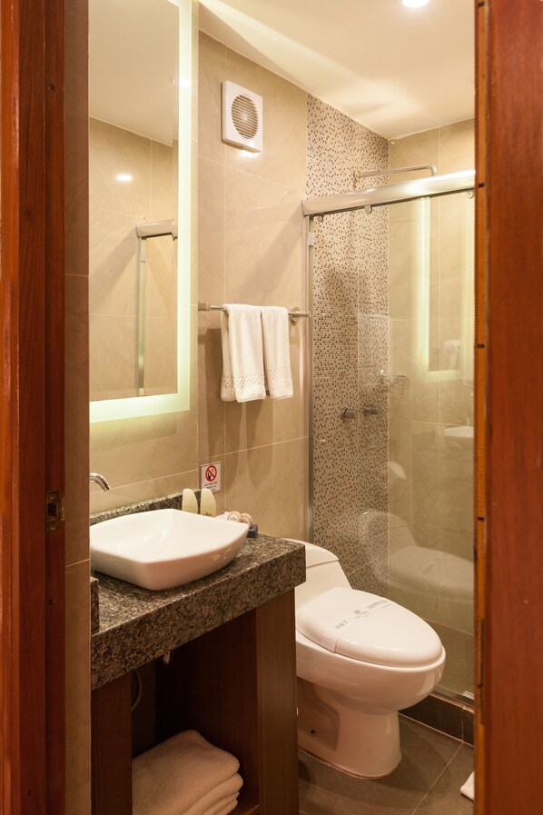 Un baño con lavamanos, inodoro y ducha.