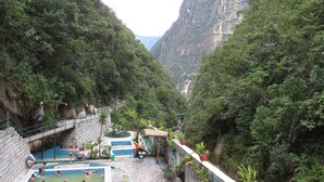 Une piscine naturelle entourée d’une végétation luxuriante et de falaises rocheuses.