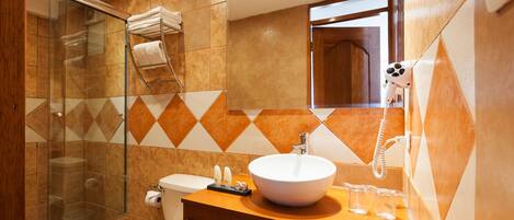A modern bathroom with a glass shower enclosure, a white sink, and a vanity with a mirror.