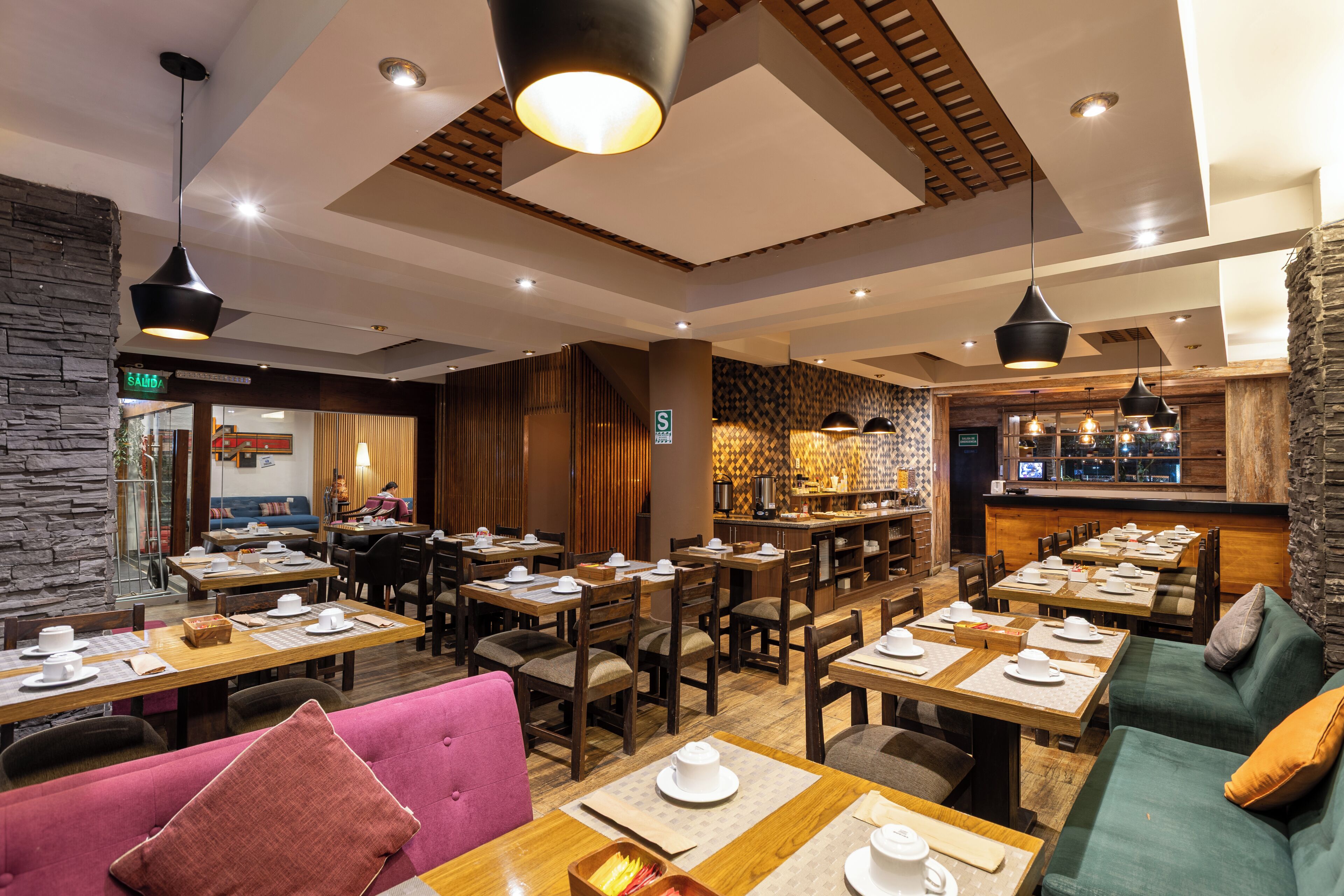 A restaurant with multiple dining tables, chairs, and a bar area.