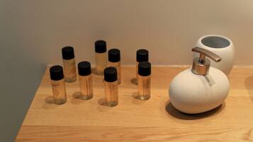 A wooden surface with several small bottles and a pump dispenser.