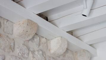 Un plafond blanc, un mur en pierre et un ventilateur de plafond blanc.