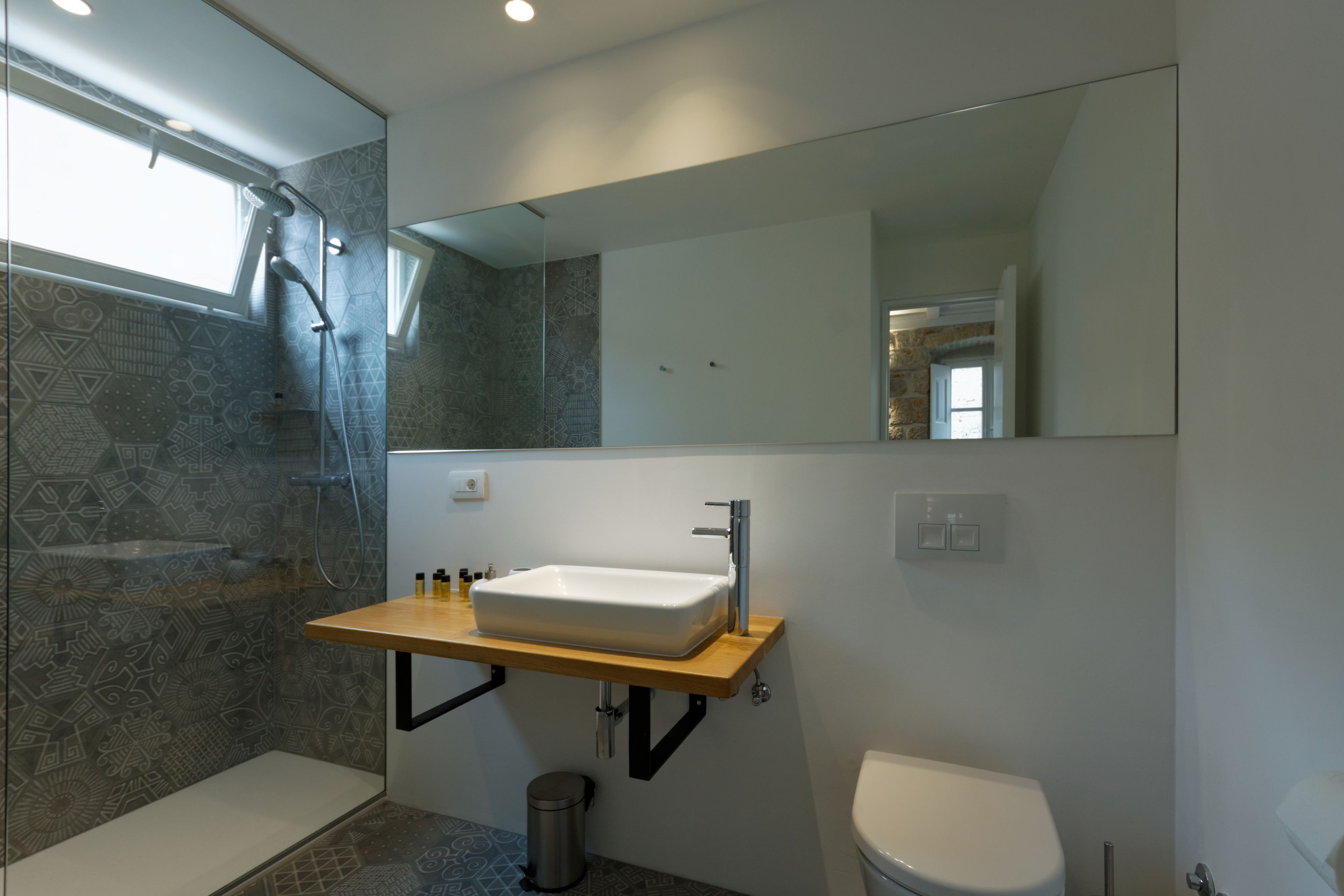 Une salle de bain moderne avec un lavabo sur pied, une douche et des toilettes.