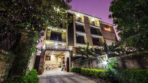 A multi-story hotel with a modern design, featuring a gated entrance, a covered walkway, and a well-lit facade. - Marie's Royale Hotel (Kampala)
