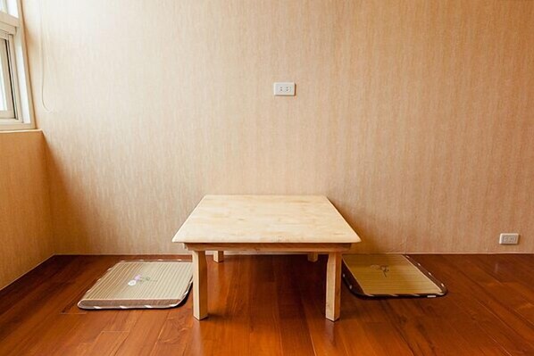 A small wooden table with a mat on the floor beside it. - Fully One B and B (Taitung)