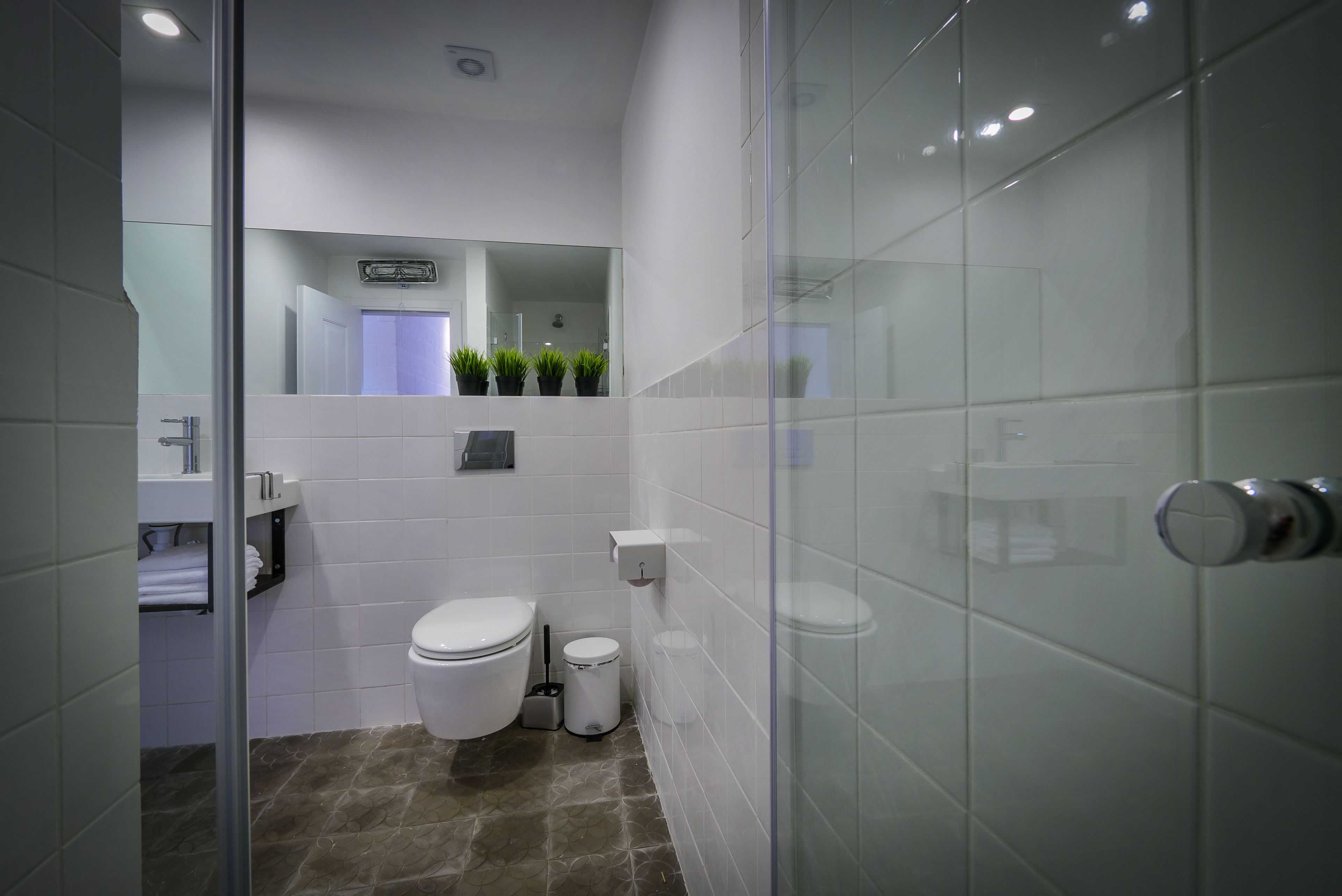 Un baño moderno con inodoro, bidé y cabina de ducha de vidrio.