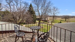 A wooden deck with a metal railing, two metal chairs, and a metal table. - After Eight Bed and Breakfast (Gordonville)