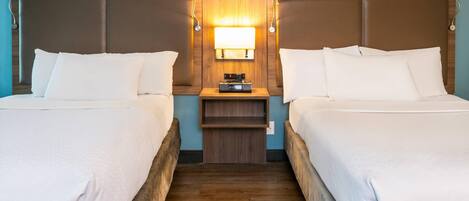 A double room with two beds, a nightstand with a lamp, and a wooden headboard.