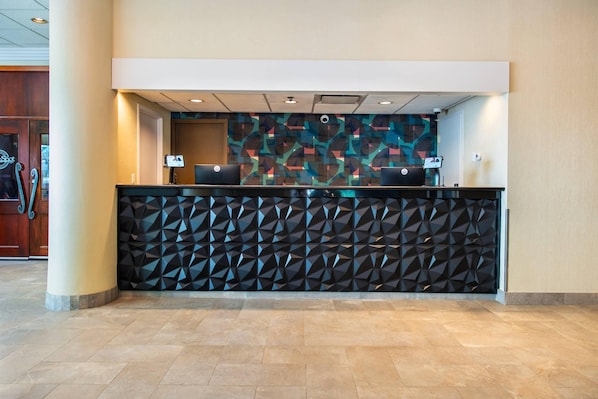A reception area with a geometric-patterned wall, two computer stations, and a tiled floor. - Grand Park Hotel & Suites Downtown Vancouver, an Ascend Collection Hotel (Vancouver)