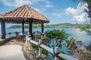 A gazebo with a tiled roof overlooking a coastal area with a view of the sea and hills. - Villa El Murmullo by La Casa Que Canta (Zihuatanejo)