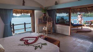 Un dormitorio con una cama grande, un escritorio y vistas al mar.