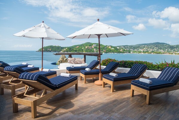 Piscine extérieure, parasols de plage, chaises longues
