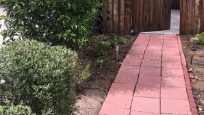 A paved pathway leading to a wooden gate. - Sunshine LA BnB (Van Nuys)