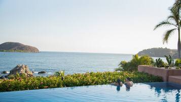 Outdoor pool, an infinity pool, pool umbrellas, pool loungers