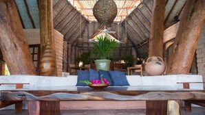 A wooden bench with a bowl of flowers and a potted plant in the center. - Villa El Ensueño by La Casa Que Canta (Zihuatanejo)