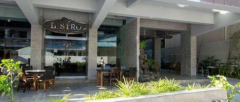 The exterior of Aloha Boracay Hotel with a signboard, outdoor seating area, and a modern architectural design.
