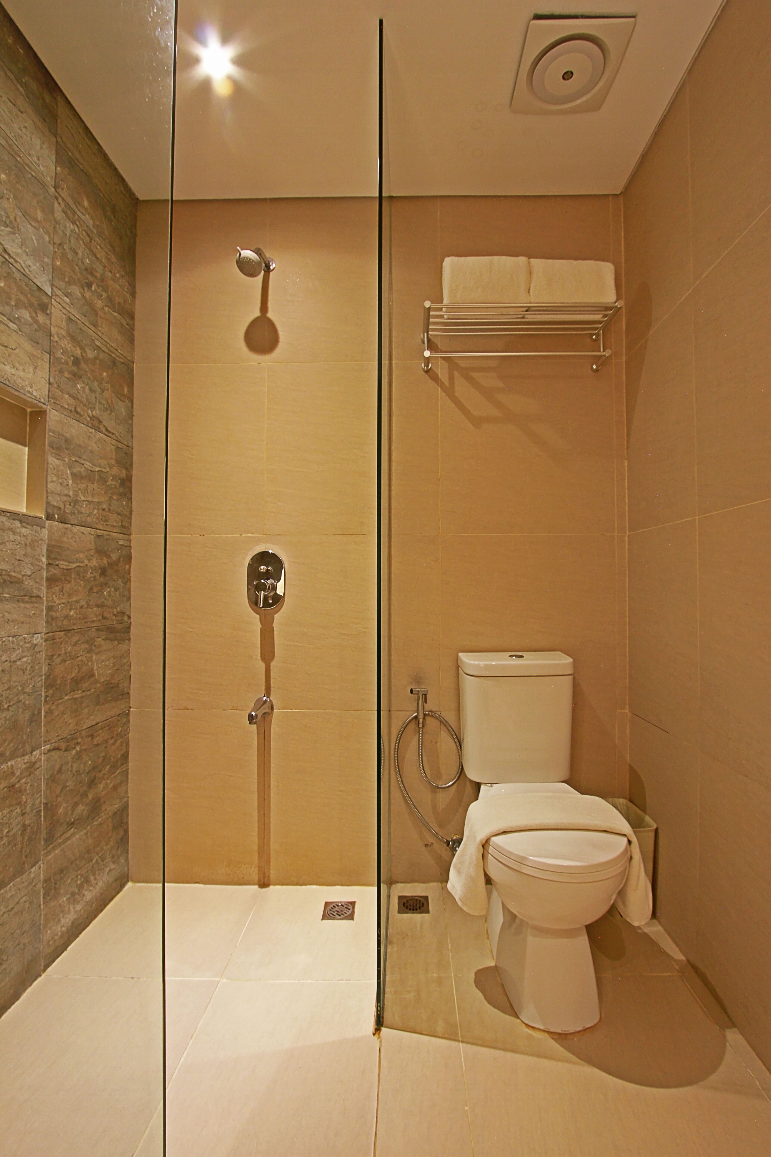 Een moderne badkamer met een douchecabine, een toilet en een handdoekhouder.
