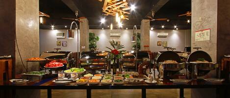 A buffet setup with various food items and a central floral arrangement.