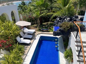 A rooftop pool with lounge chairs and a view of the beach. - Villa de la Roca (Zihuatanejo)