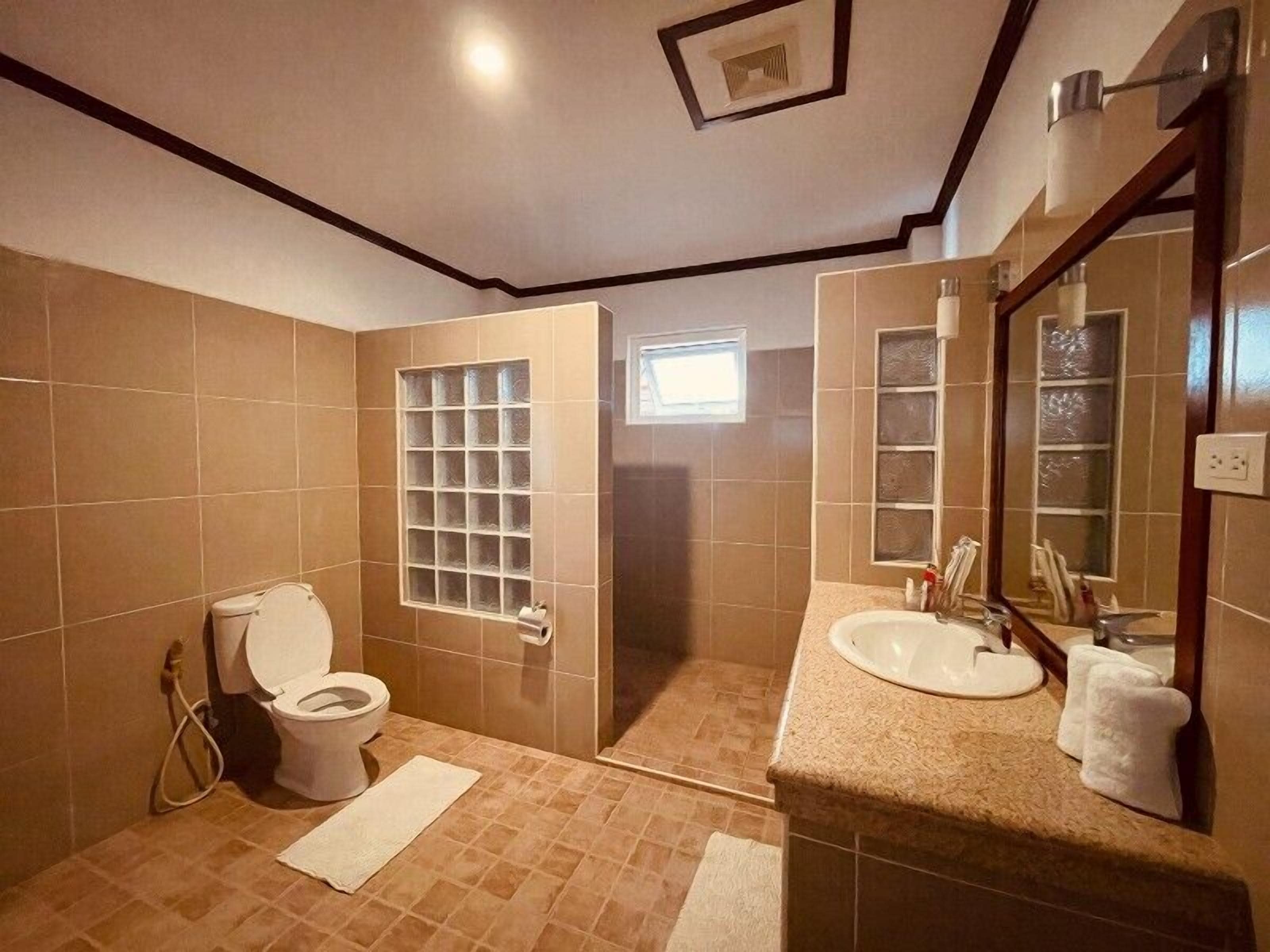 Un bagno con WC, lavandino e specchio.