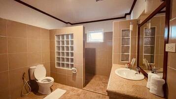Un bagno con WC, lavandino e specchio.