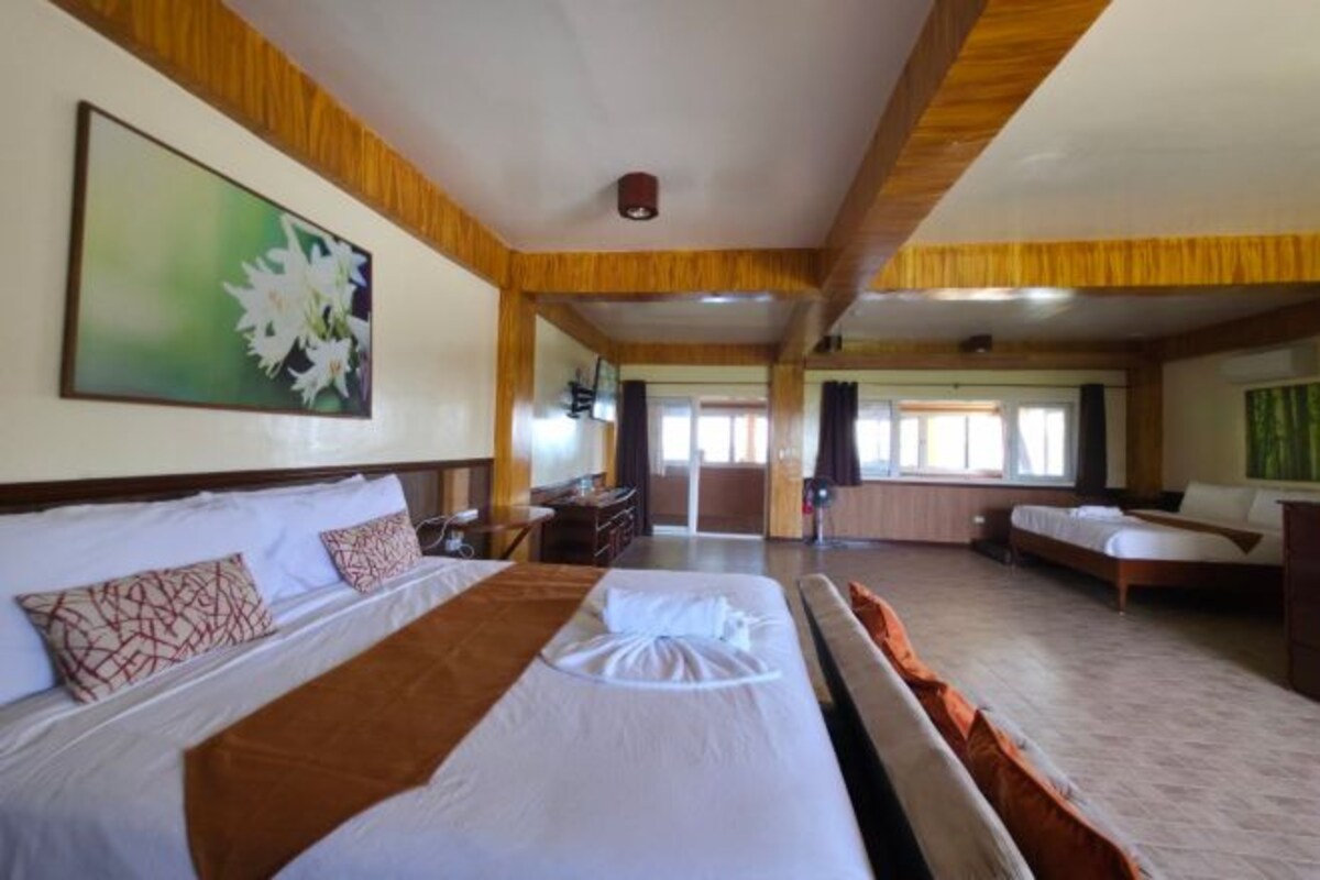 Una habitación de hotel con una cama grande, un escritorio y un espacio de descanso.