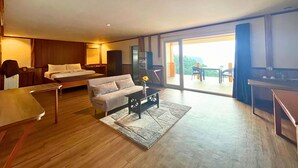Una habitación de hotel moderna con cama, sofá y zona de comedor.